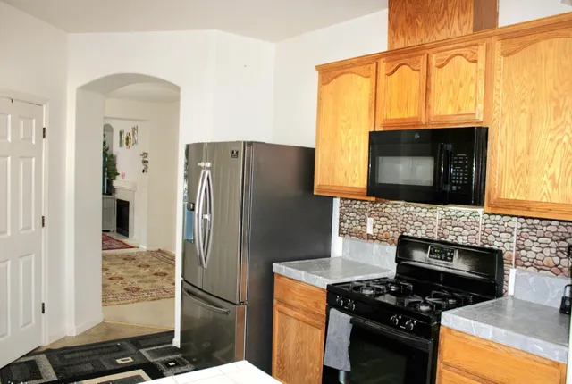 a kitchen with a stove a refrigerator and a microwave