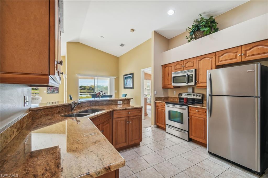 21629 Windham Run Estero, FL 33928 - Photo 4 of 23 a kitchen with stainless steel appliances granite countertop a refrigerator a stove top oven a sink and dishwasher