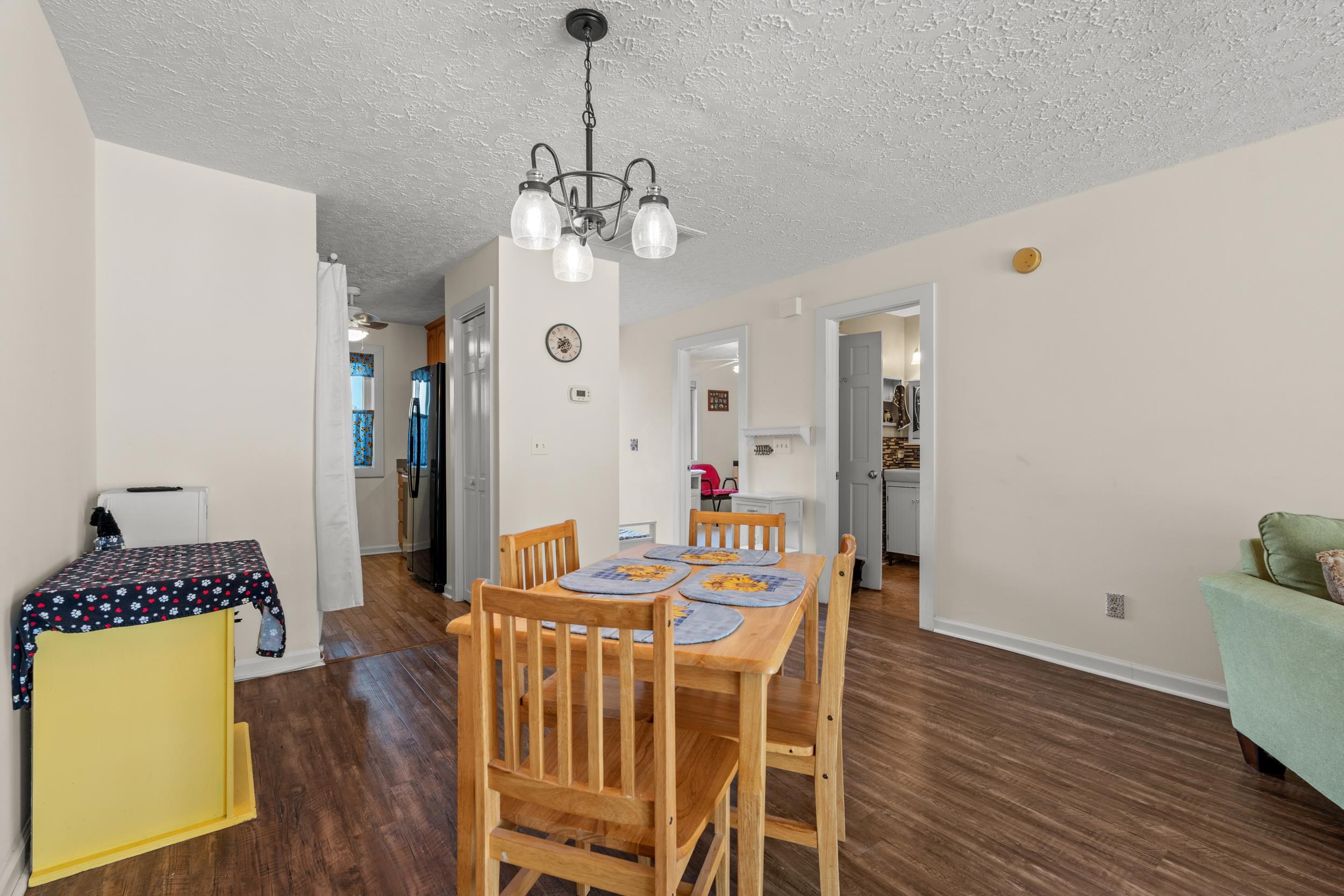 3015 Old Bryan Drive, Unit 97 Myrtle Beach, SC 29577 - Photo 11 of 35 Dining room with a chandelier, a textured ceiling, wood finished floors, and baseboards