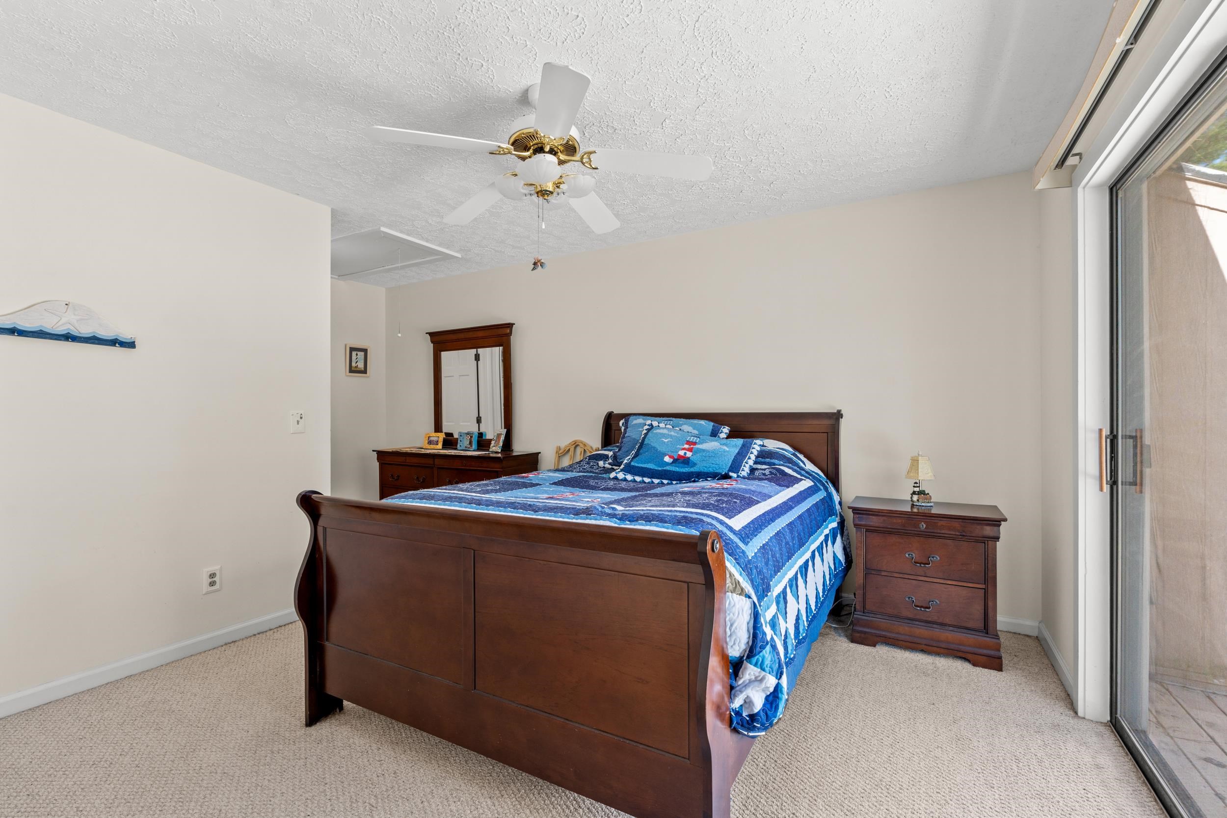 3015 Old Bryan Drive, Unit 97 Myrtle Beach, SC 29577 - Photo 15 of 35 Bedroom featuring light carpet, a ceiling fan, and a textured ceiling