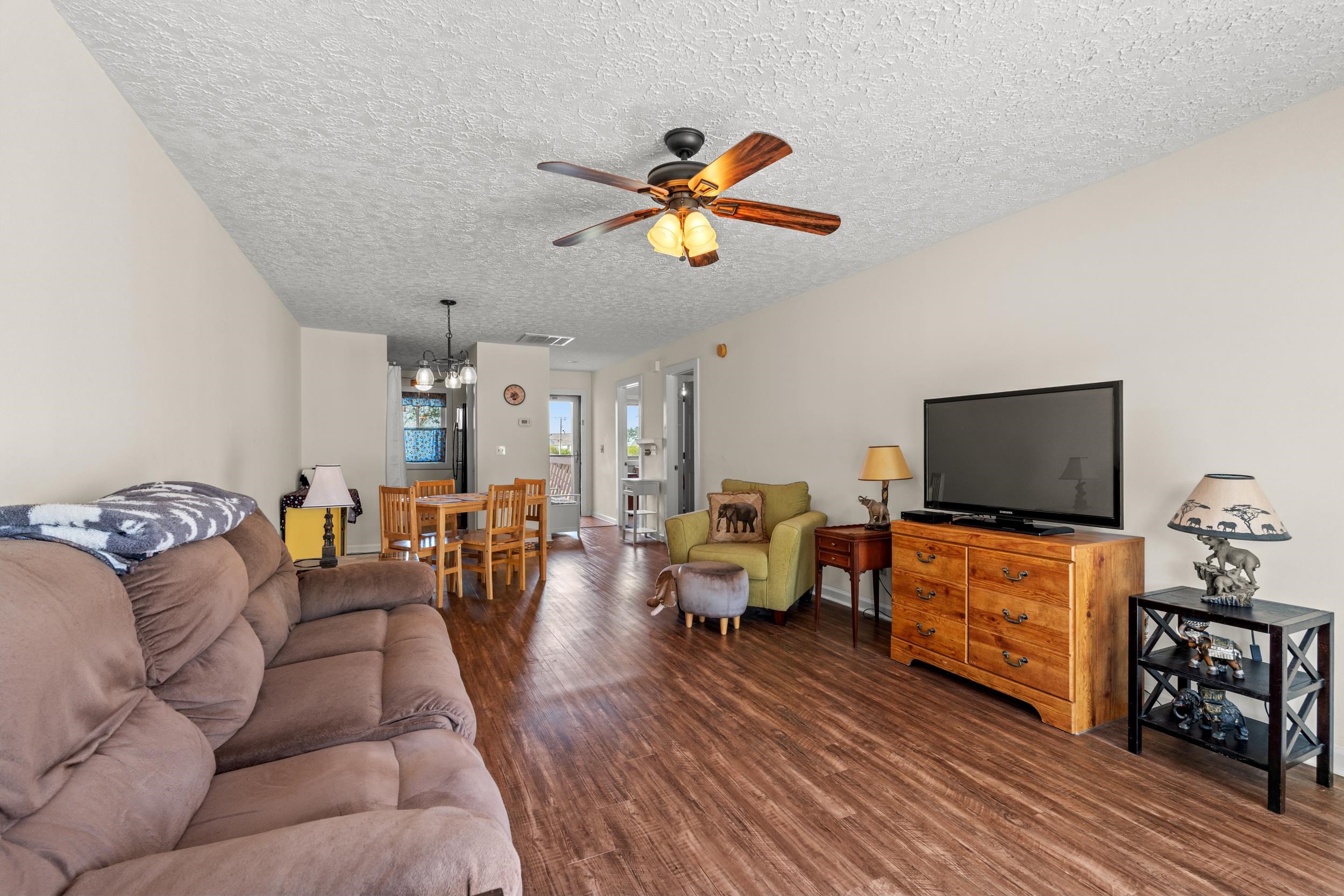 3015 Old Bryan Drive, Unit 97 Myrtle Beach, SC 29577 - Photo 4 of 35 Living room featuring a textured ceiling, ceiling fan with notable chandelier, wood finished floors, and visible vents