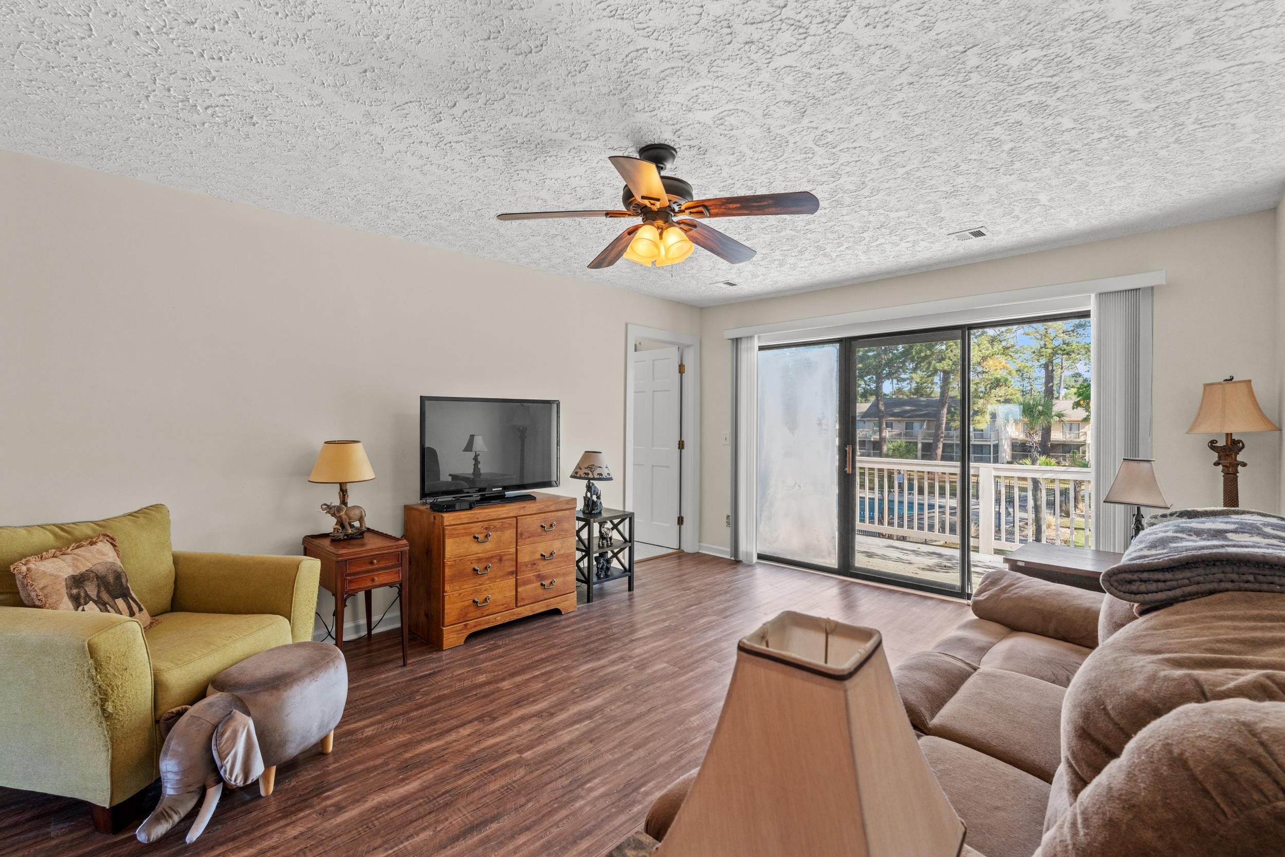 3015 Old Bryan Drive, Unit 97 Myrtle Beach, SC 29577 - Photo 6 of 35 Living area featuring visible vents, baseboards, a ceiling fan, a textured ceiling, and wood finished floors