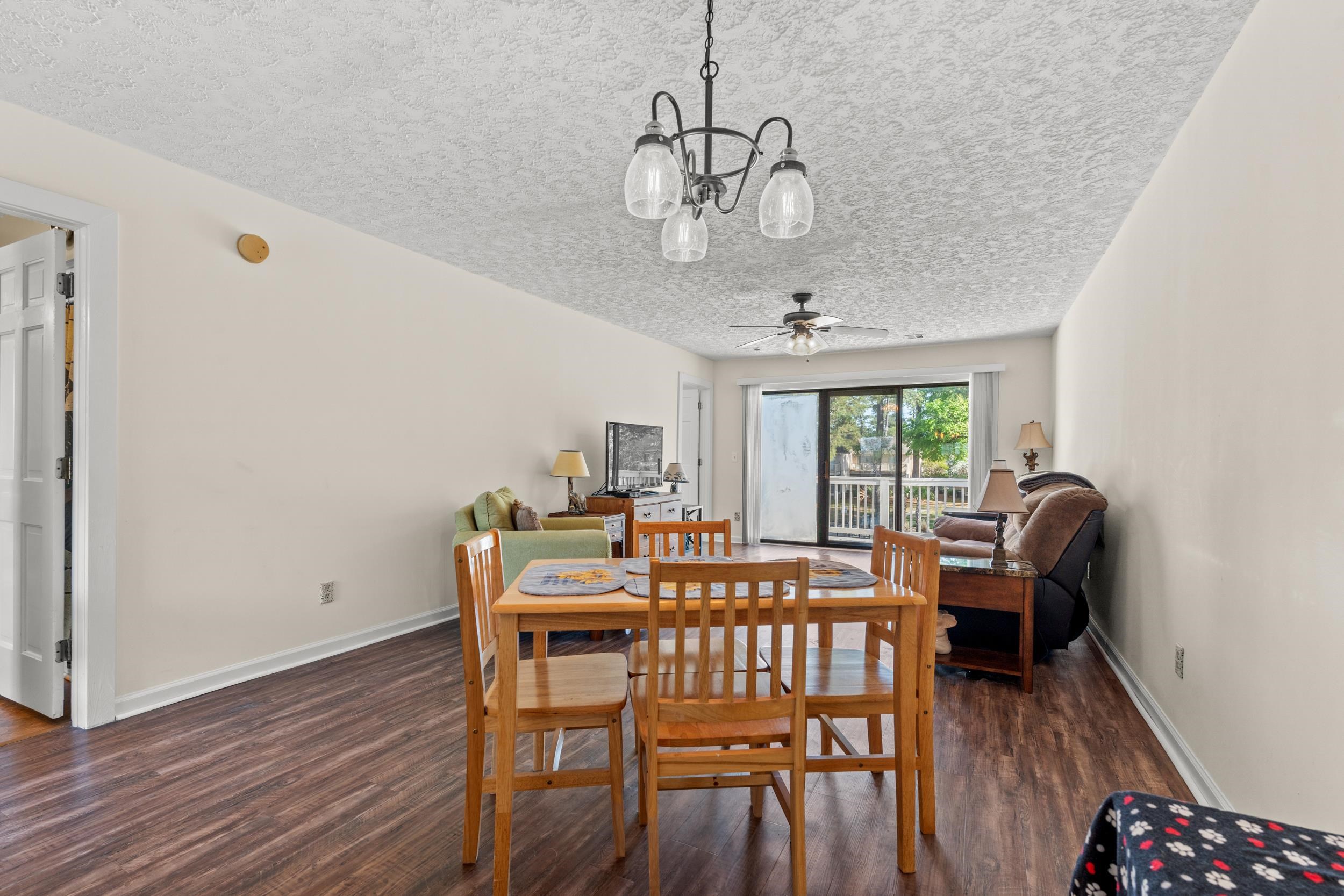 3015 Old Bryan Drive, Unit 97 Myrtle Beach, SC 29577 - Photo 10 of 35 Dining area with baseboards, a textured ceiling, wood finished floors, and ceiling fan with notable chandelier