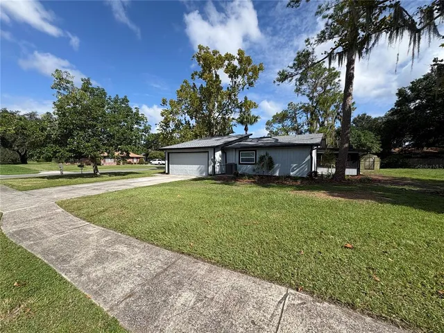 a front view of a house with a yard and trees
