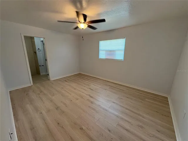 a view of an empty room with a chandelier fan