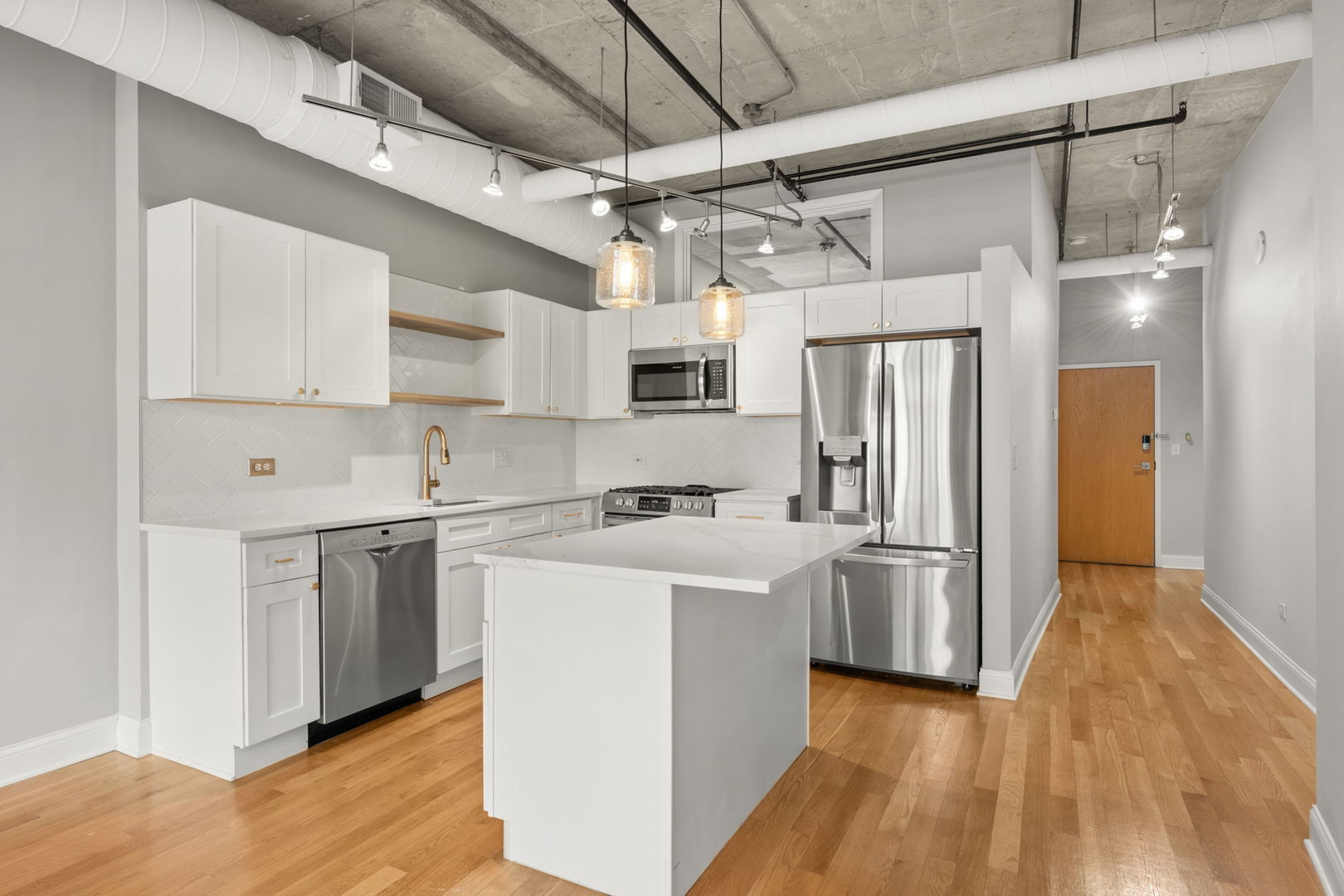 933 West Van Buren Street, Unit 508 Chicago, IL 60607 - Photo 14 of 25 a kitchen with stainless steel appliances a refrigerator a sink dishwasher a stove and white cabinets with wooden floor
