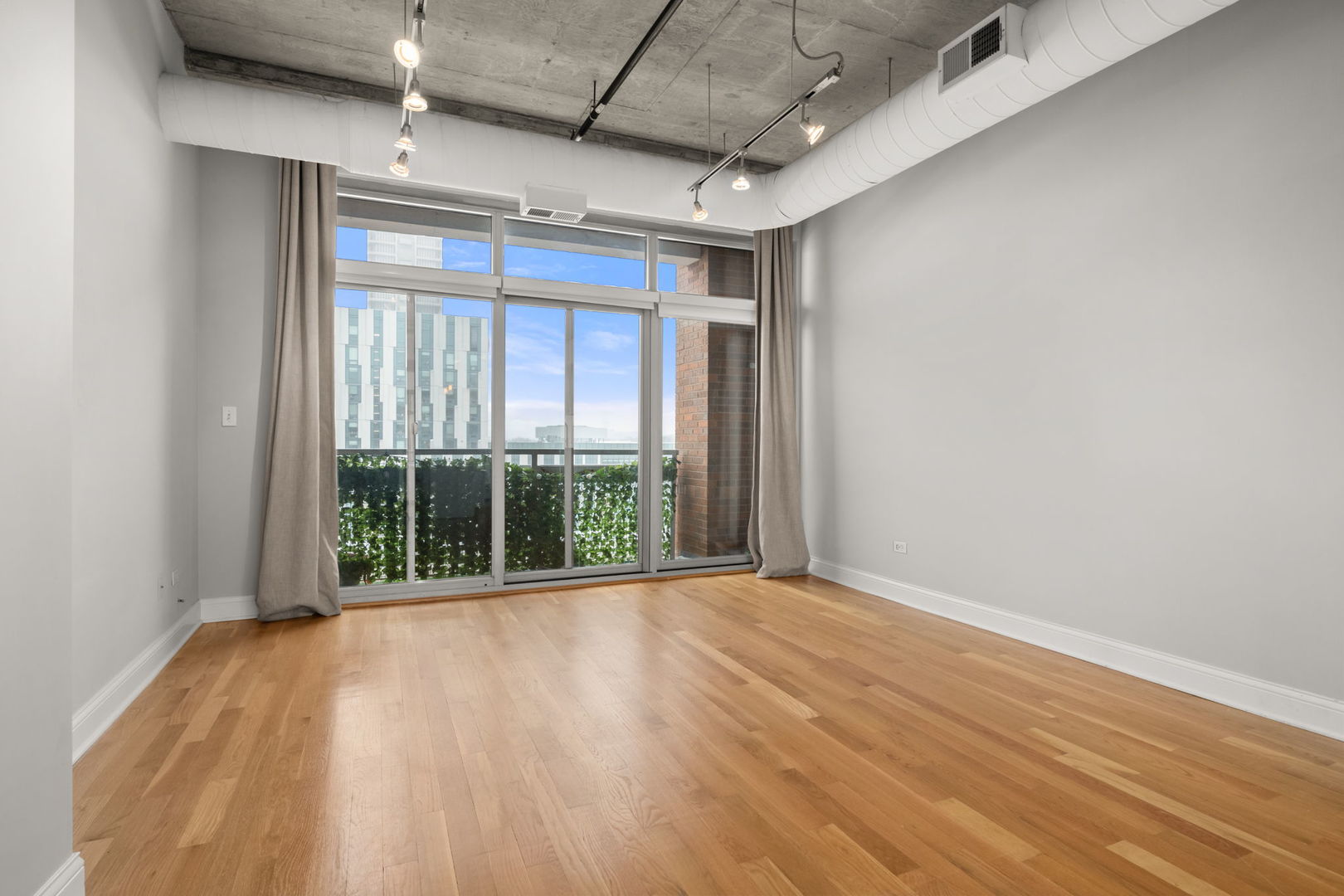 933 West Van Buren Street, Unit 508 Chicago, IL 60607 - Photo 16 of 25 an empty room with wooden floor and windows