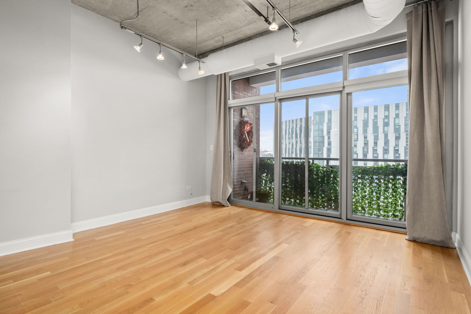 933 West Van Buren Street, Unit 508 Chicago, IL 60607 - Photo 17 of 25 an empty room with wooden floor and windows