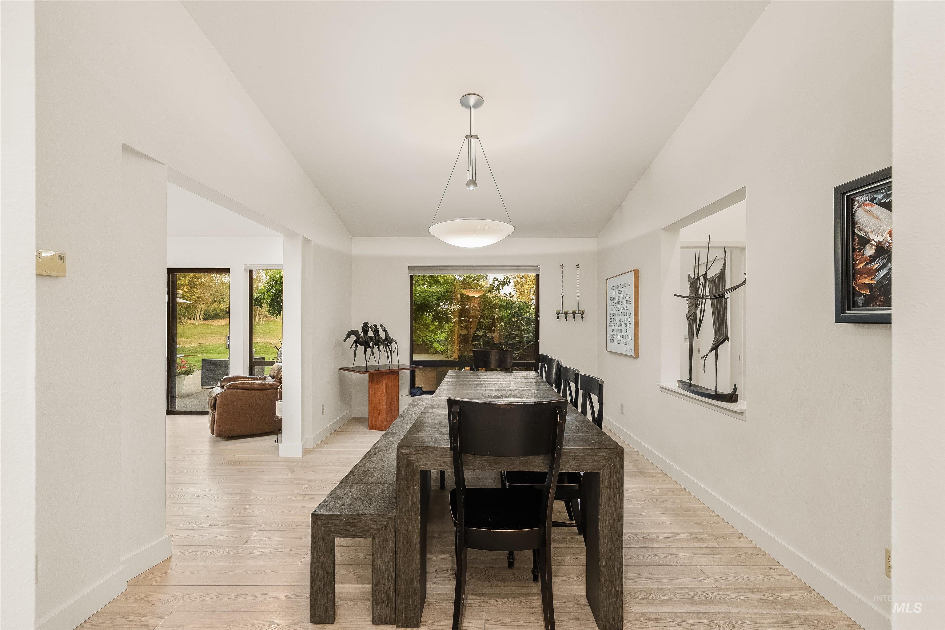 2048 Arborcrest Road Moscow, ID 83843 - Photo 20 of 50 Spacious dining area with light wood-finish flooring, a contemporary pendant light fixture, and large windows providing ample natural light