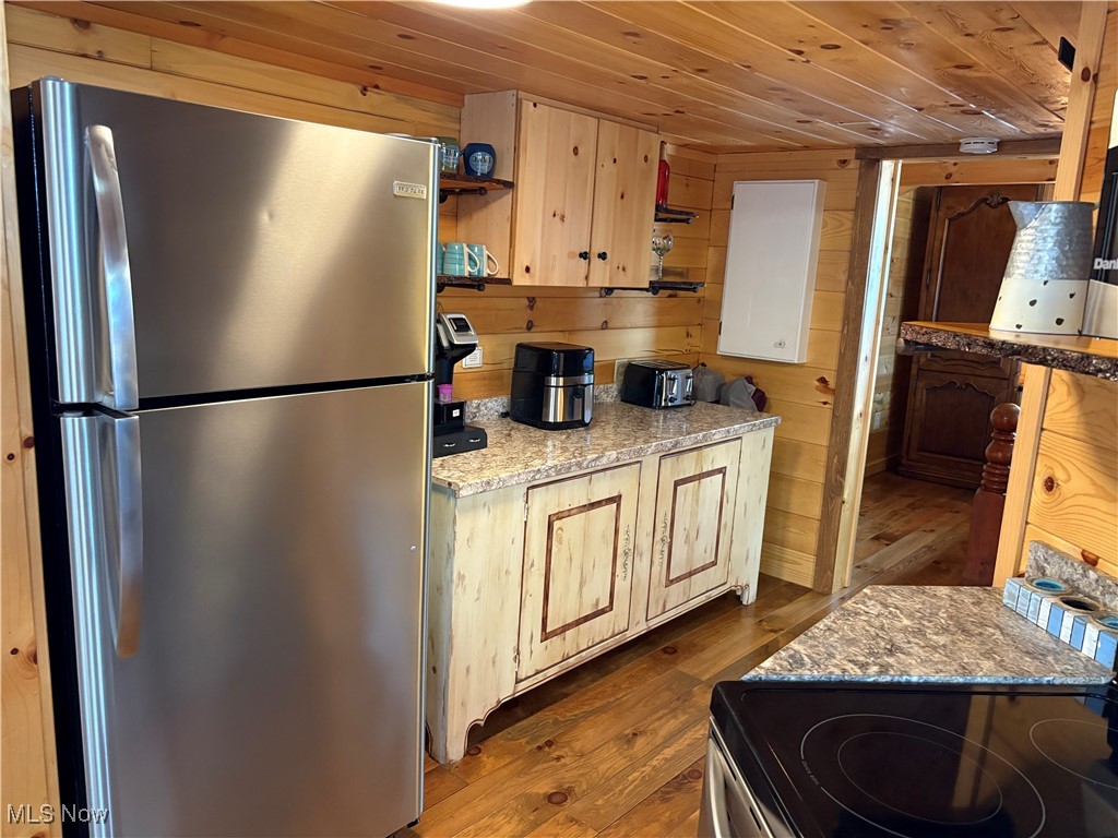 5919 Lake Road West, Unit 13 Ashtabula, OH 44004 - Photo 12 of 35 Kitchen featuring open shelves, freestanding refrigerator, dark wood-type flooring, wood ceiling, and wooden walls