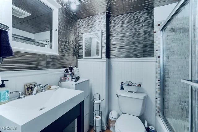 a bathroom with a sink a toilet and shower curtain