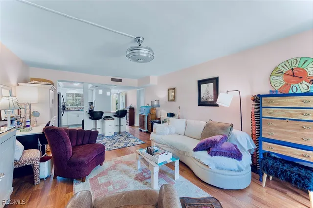a living room with furniture a couch and paintings on the wall