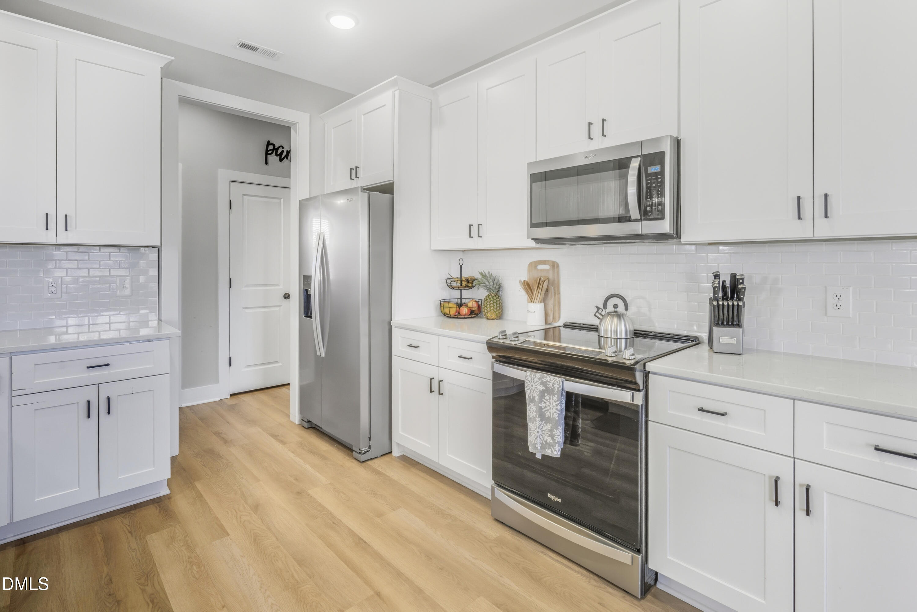 6039 Farmwood Loop Wilson, NC 27896 - Photo 9 of 27 a kitchen with white cabinets and stainless steel appliances