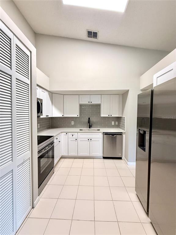 758 Warrenton Road Winter Park, FL 32792 - Photo 11 of 52 a kitchen with stainless steel appliances granite countertop a stove a sink and a refrigerator