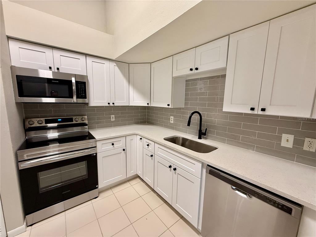 758 Warrenton Road Winter Park, FL 32792 - Photo 13 of 52 a kitchen with white cabinets a sink and a stove