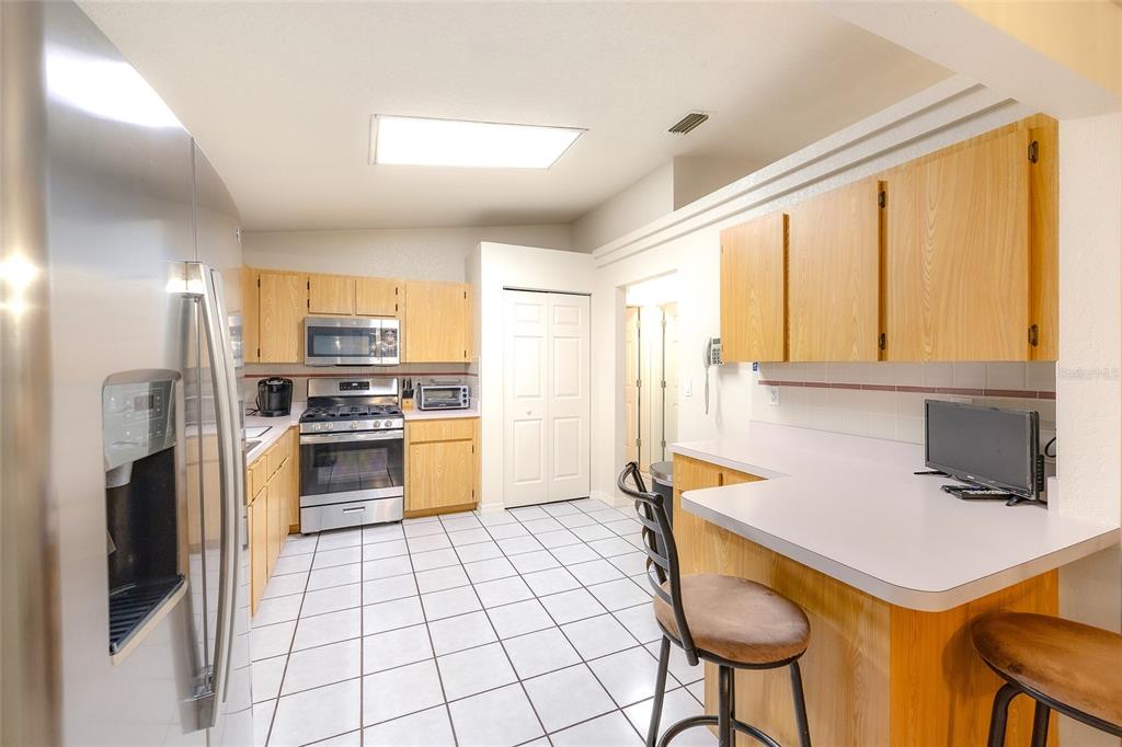 4513 Southwest 158th St Road Ocala, FL 34473 - Photo 14 of 41 a kitchen with stainless steel appliances a stove refrigerator sink and cabinets
