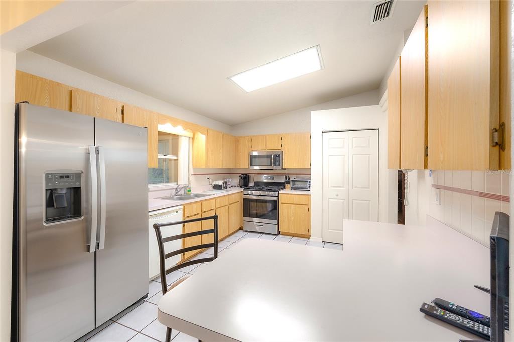 4513 Southwest 158th St Road Ocala, FL 34473 - Photo 16 of 41 a kitchen with stainless steel appliances a refrigerator and a stove top oven
