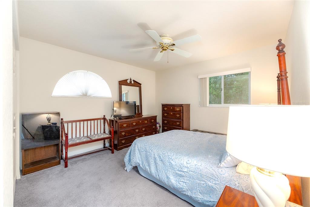 4513 Southwest 158th St Road Ocala, FL 34473 - Photo 23 of 41 a bedroom with a bed and a chandelier