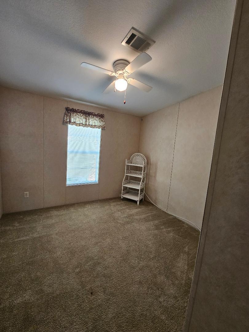 4317 71st Street North, Unit 1277 Riviera Beach, FL 33404 - Photo 12 of 19 an empty room with windows and fan