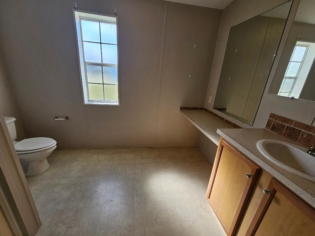 4317 71st Street North, Unit 1277 Riviera Beach, FL 33404 - Photo 13 of 19 a bathroom with a sink toilet and a window