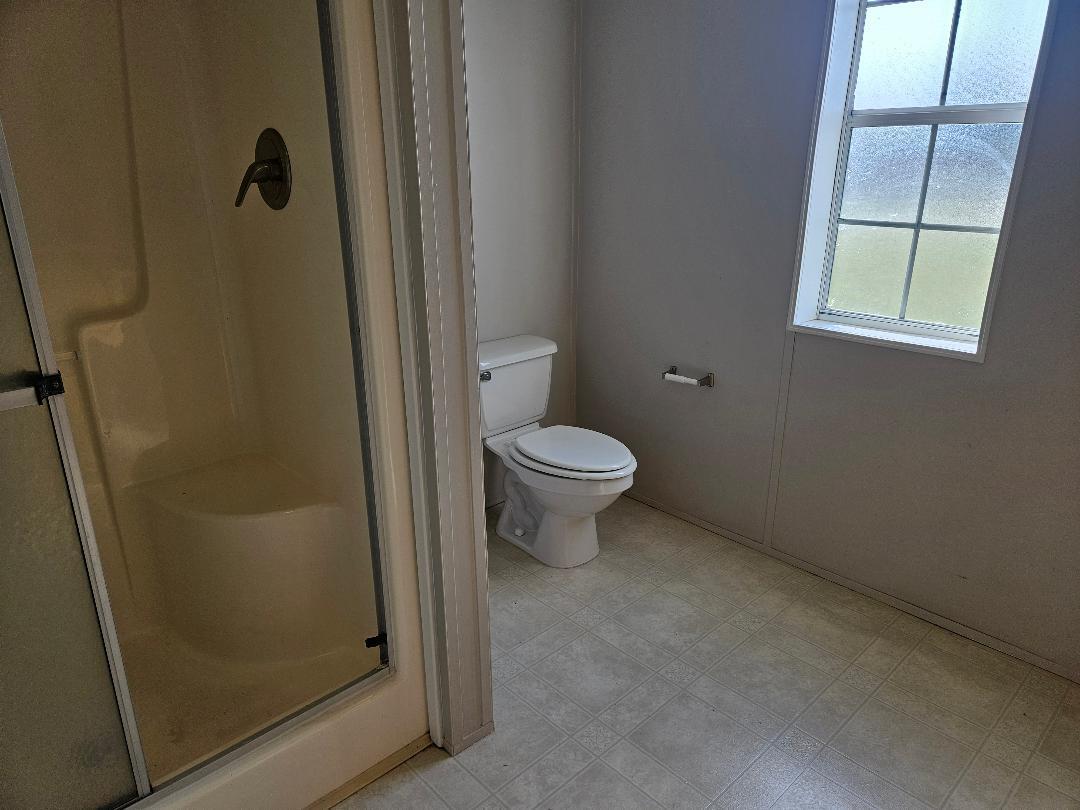 4317 71st Street North, Unit 1277 Riviera Beach, FL 33404 - Photo 14 of 19 a bathroom with a granite countertop toilet and a shower