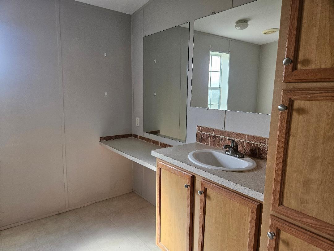 4317 71st Street North, Unit 1277 Riviera Beach, FL 33404 - Photo 16 of 19 a bathroom with a sink and a mirror