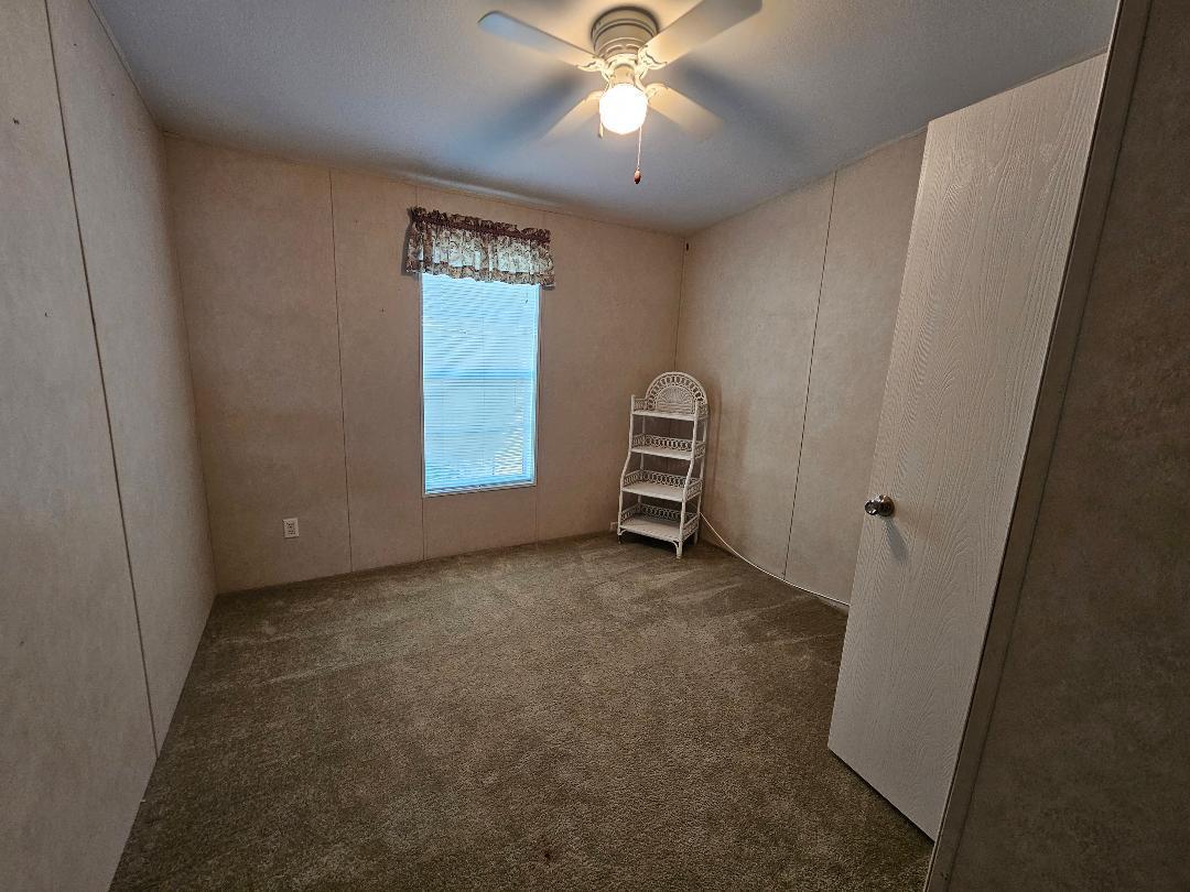 4317 71st Street North, Unit 1277 Riviera Beach, FL 33404 - Photo 17 of 19 a view of a livingroom with a ceiling fan and window