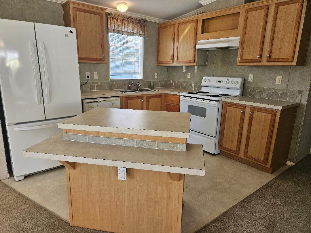 4317 71st Street North, Unit 1277 Riviera Beach, FL 33404 - Photo 2 of 19 a kitchen with stainless steel appliances a refrigerator sink and cabinets