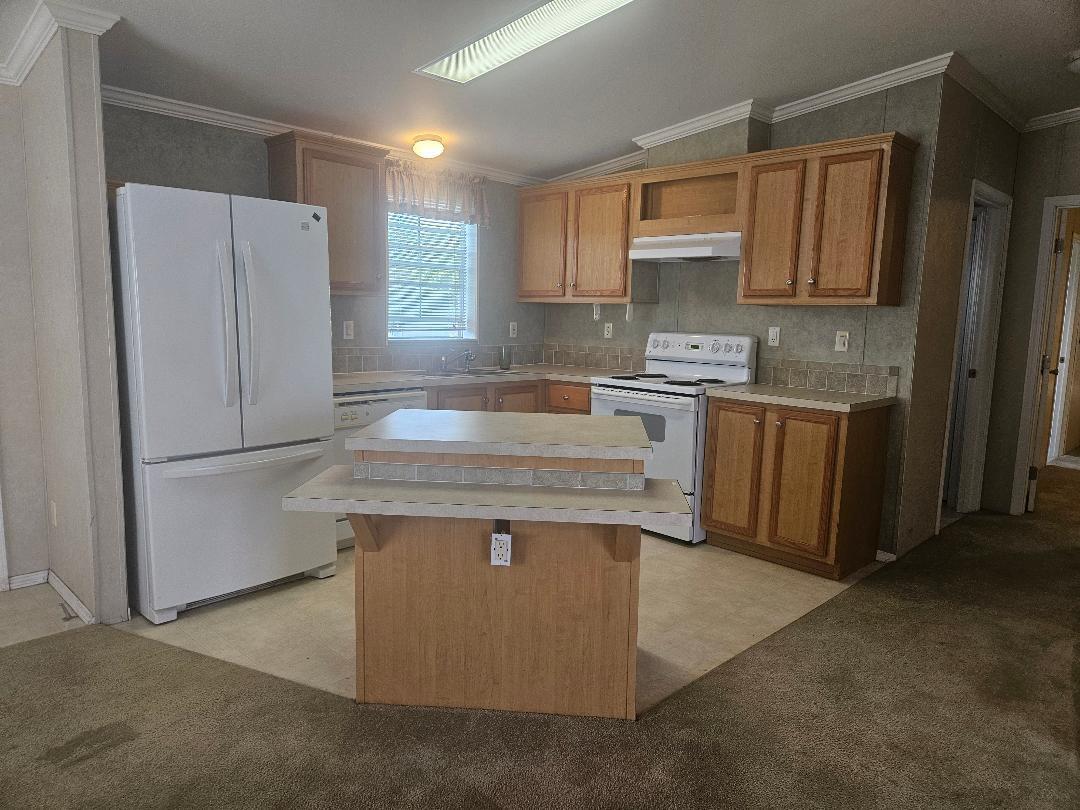 4317 71st Street North, Unit 1277 Riviera Beach, FL 33404 - Photo 4 of 19 a kitchen with stainless steel appliances granite countertop a refrigerator a stove a sink and a microwave