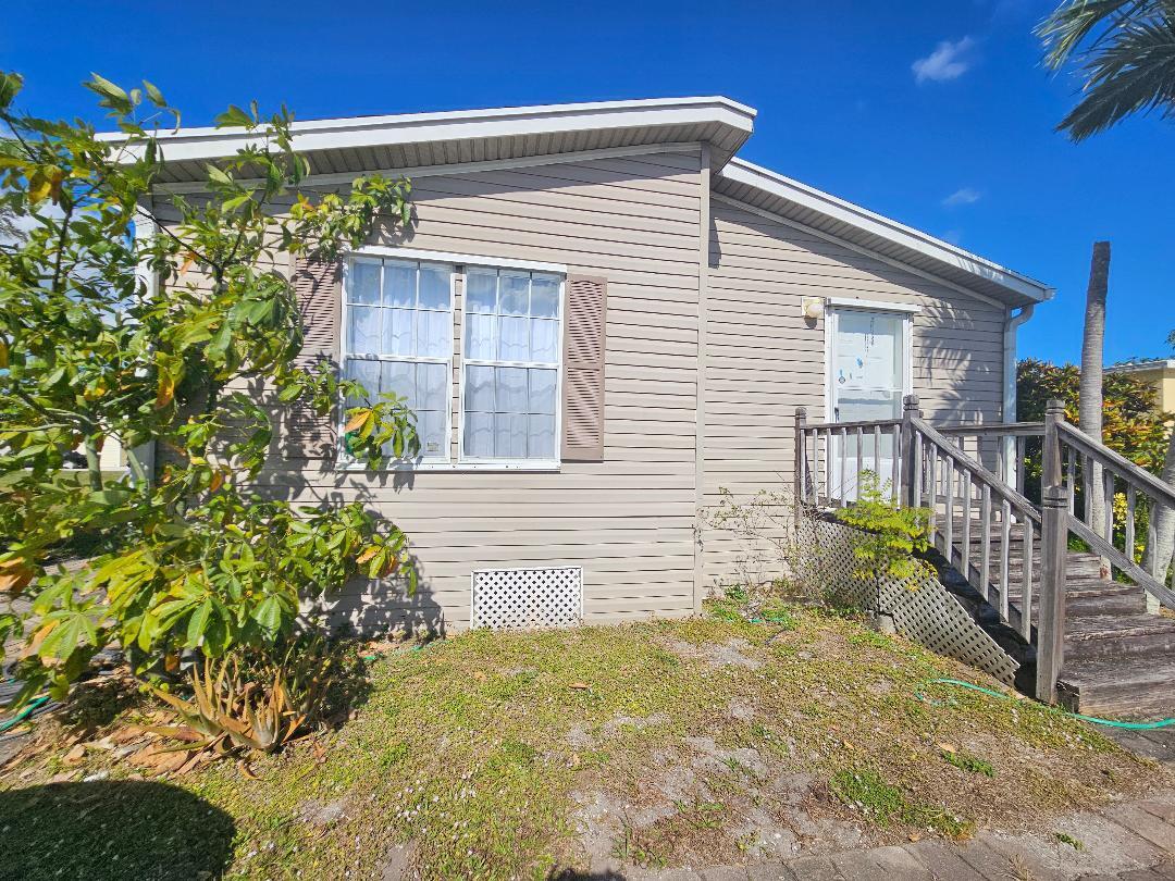 4317 71st Street North, Unit 1277 Riviera Beach, FL 33404 - Photo 6 of 19 a front view of a house with a yard