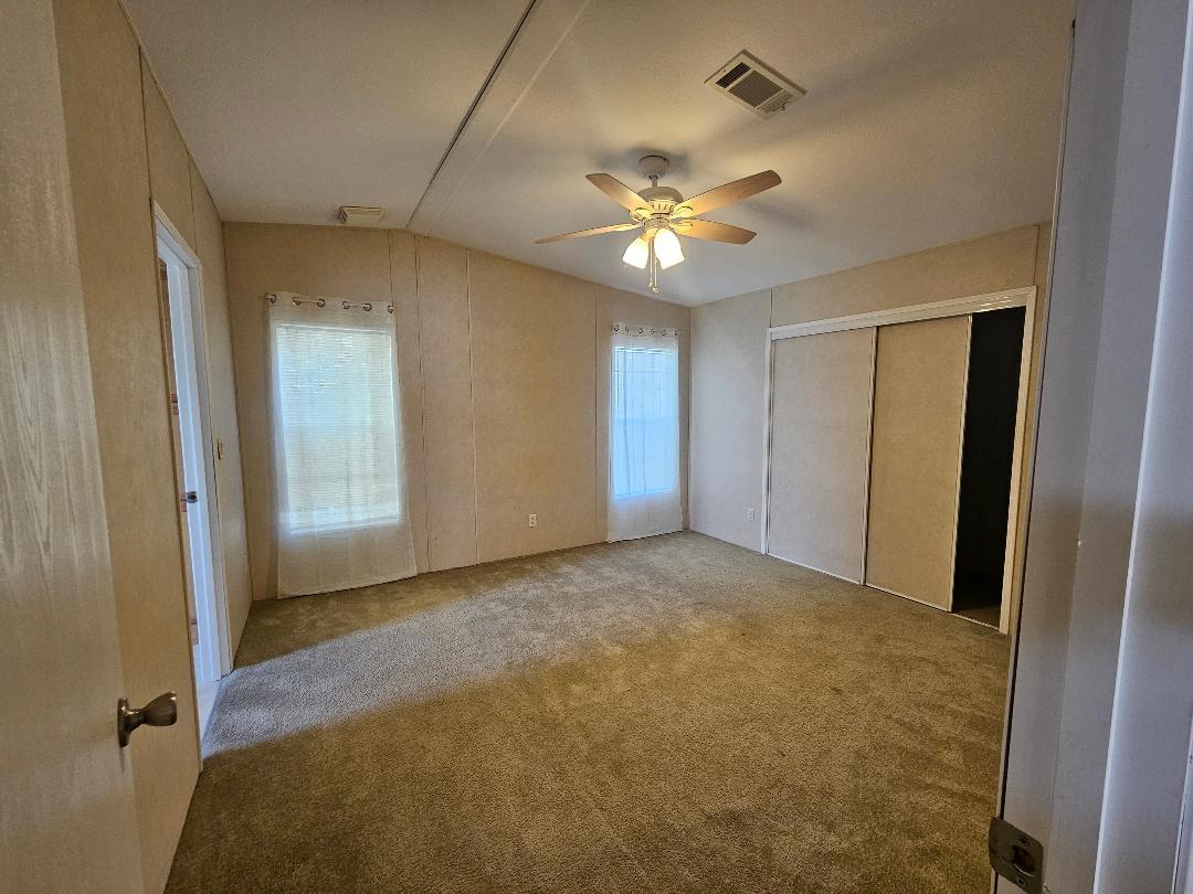 4317 71st Street North, Unit 1277 Riviera Beach, FL 33404 - Photo 8 of 19 a view of an empty room with a chandelier fan