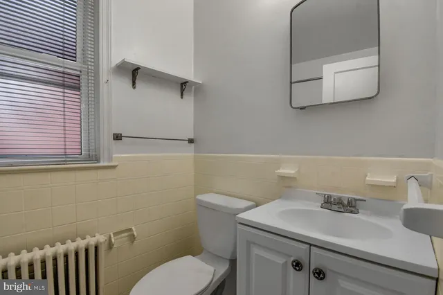 a bathroom with a sink a toilet and a mirror