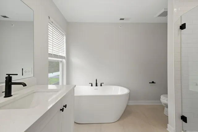a bathroom with a sink a toilet and a large mirror