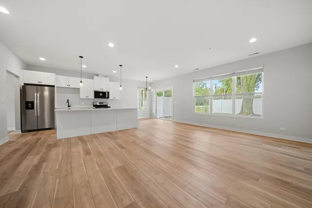 a view of kitchen with wooden floor and electronic appliances