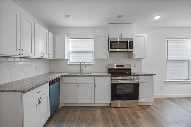 a kitchen with stainless steel appliances granite countertop a stove and a sink
