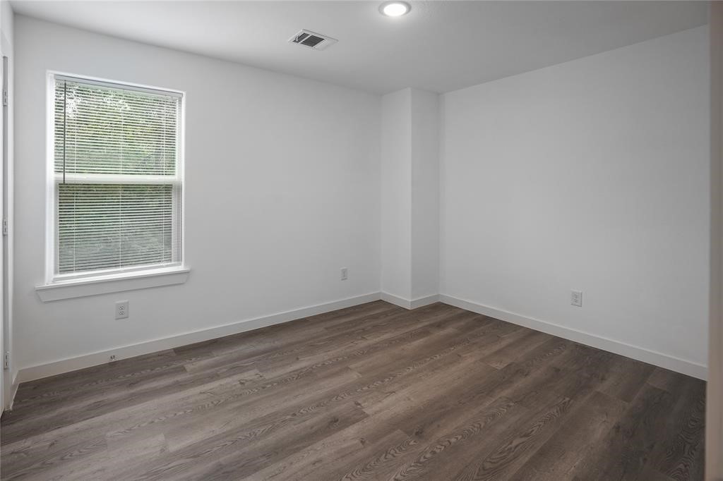 9313 Hillis Street, Unit A Houston, TX 77028 - Photo 6 of 14 an empty room with wooden floor and windows