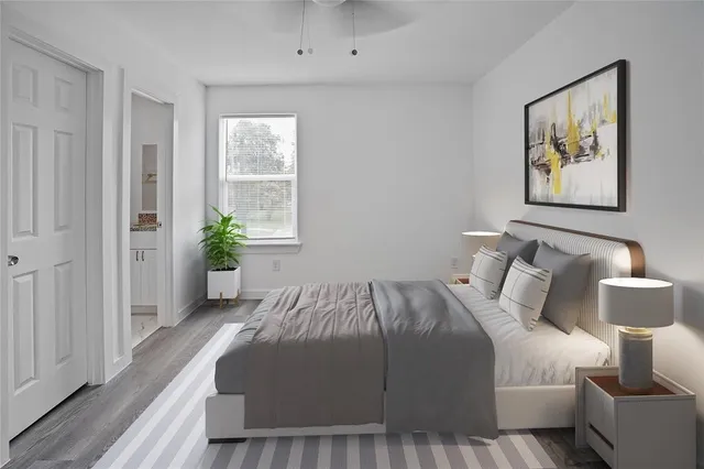 a bedroom with a bed painting on wall and a potted plant