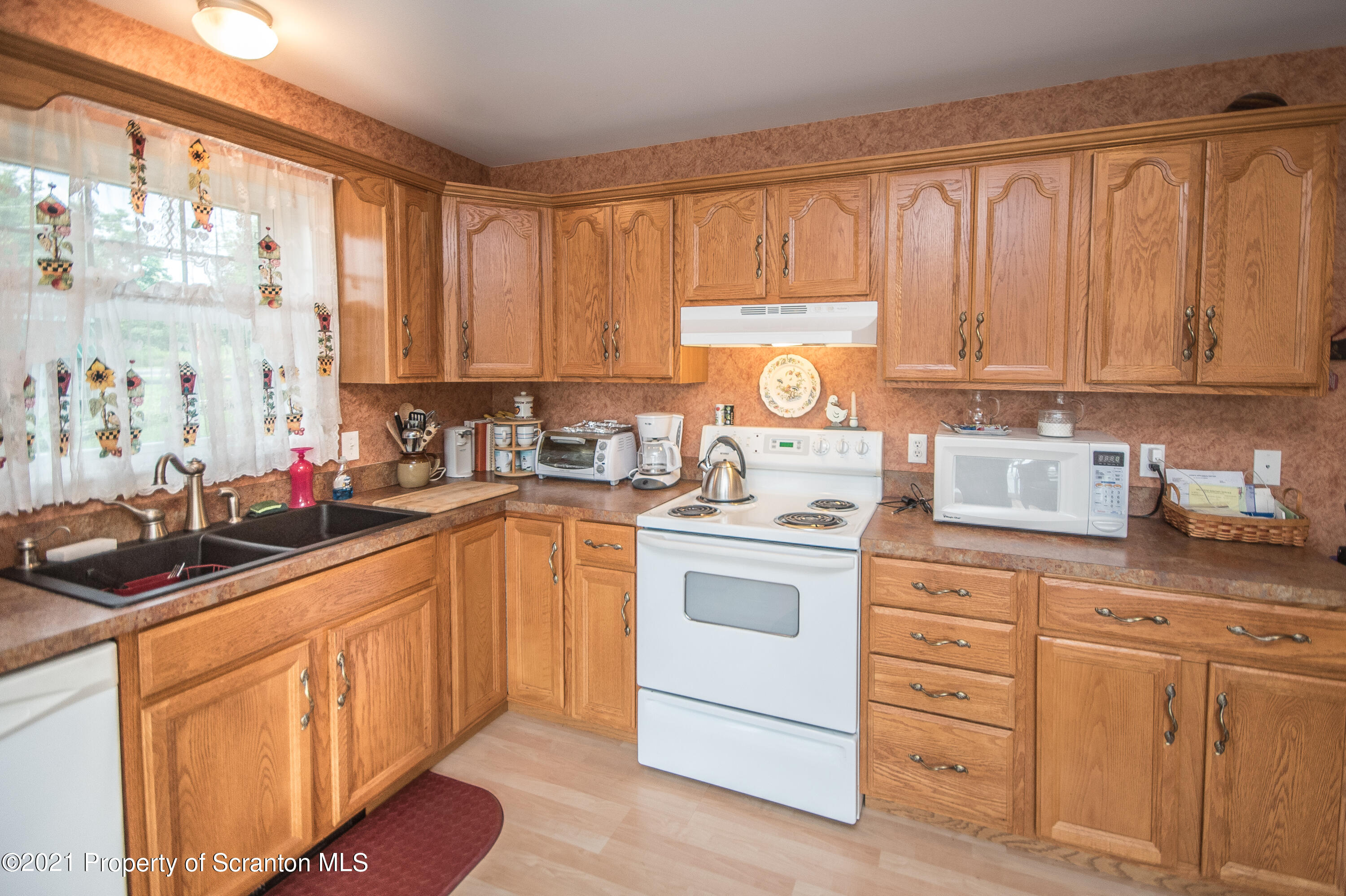 34 Taylor Farm Road Union Dale, PA 18470 - Photo 16 of 38 a kitchen with granite countertop white cabinets sink and white appliances