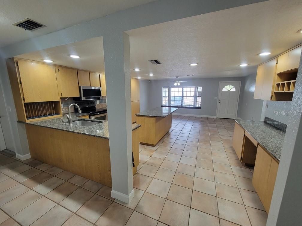 11633 Fox Run Port Richey, FL 34668 - Photo 8 of 33 a view of a kitchen with kitchen island granite countertop a large counter top space appliances and a sink