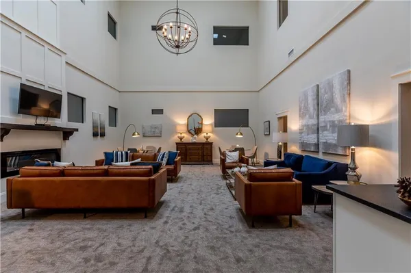 a living room with furniture a flat screen tv and kitchen view