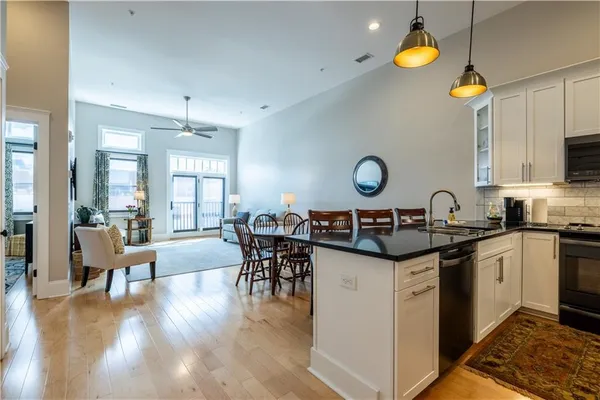 a kitchen with kitchen island granite countertop a sink stainless steel appliances and cabinets