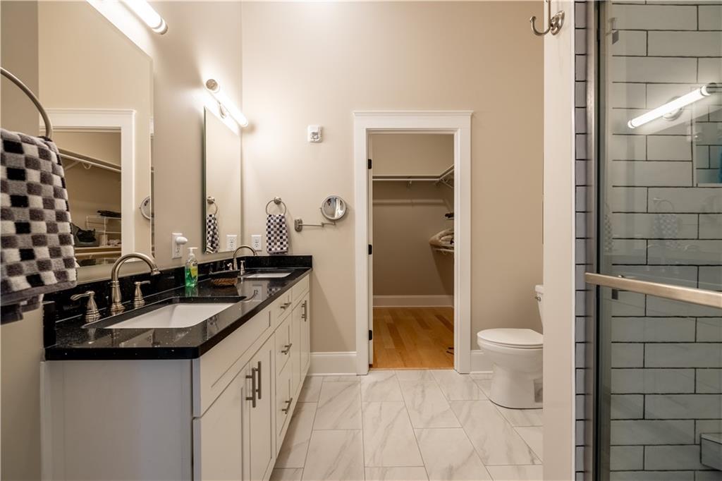 1 East 3rd Avenue, Unit 302 Rome, GA 30161 - Photo 10 of 36 a bathroom with a granite countertop sink a toilet a mirror and shower