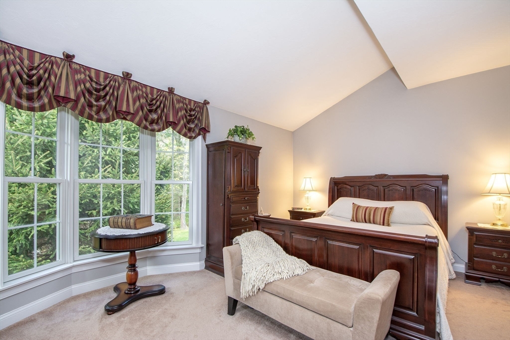 53 Hemlock Circle, Unit 53 Hanover, MA 02339 - Photo 12 of 27 a bedroom with a bed and a chandelier