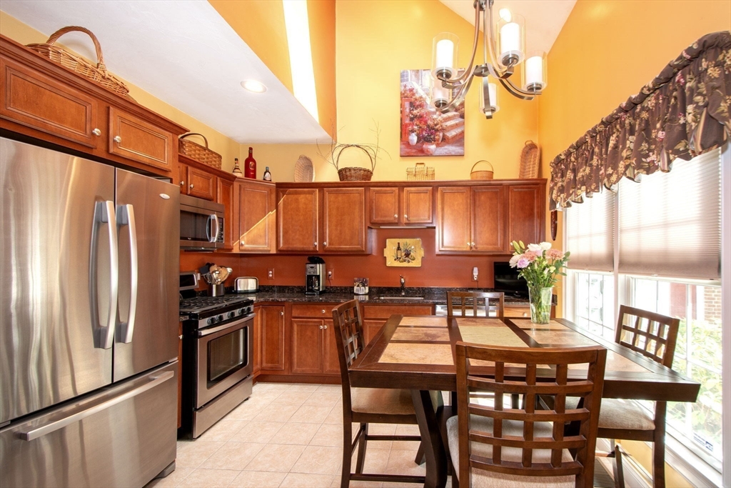 53 Hemlock Circle, Unit 53 Hanover, MA 02339 - Photo 9 of 27 a kitchen with stainless steel appliances granite countertop a stove a refrigerator and a dining table