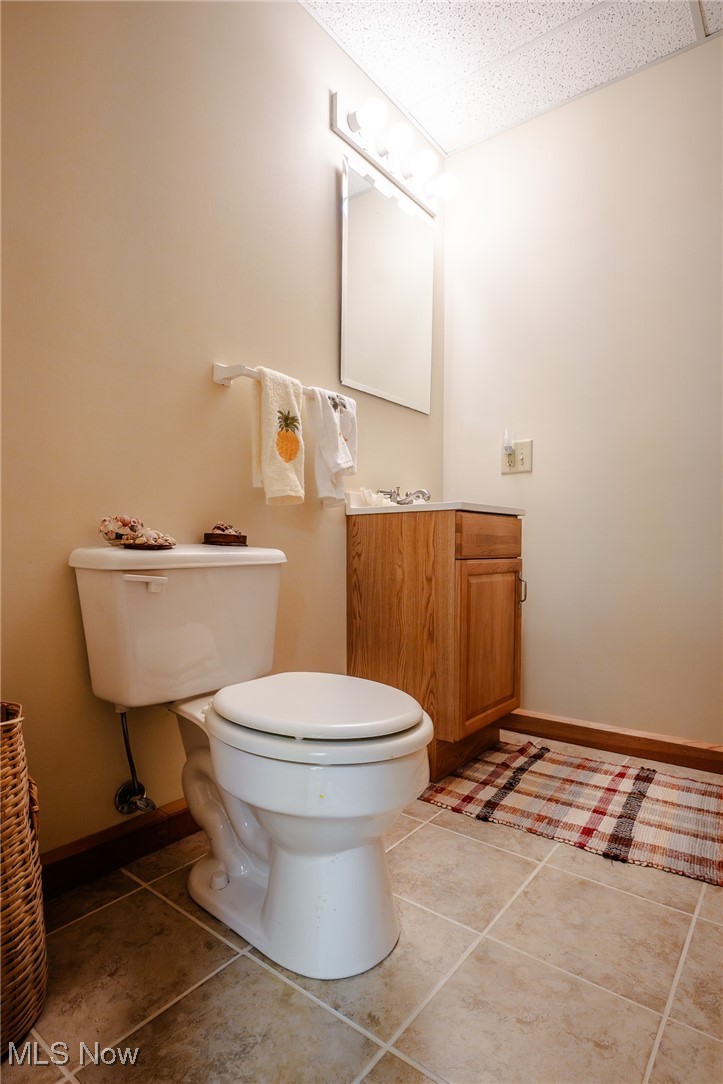 3421 Ridge Road Northwest Bolivar, OH 44612 - Photo 25 of 45 Half bath with baseboards, vanity, toilet, and tile patterned floors