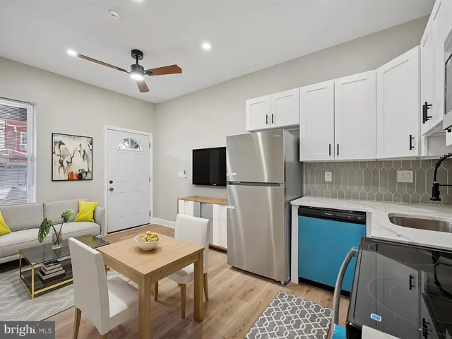 a kitchen with a refrigerator a stove a sink dishwasher and white cabinets with wooden floor