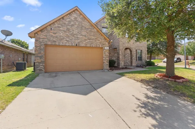 a view of backyard of house with garage and large trees