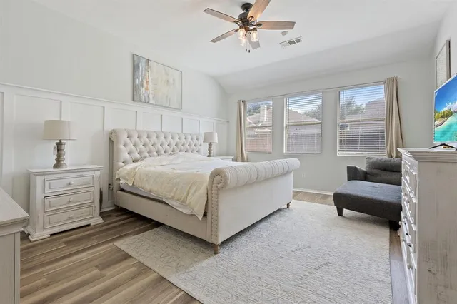 a bedroom with a bed and wooden floor