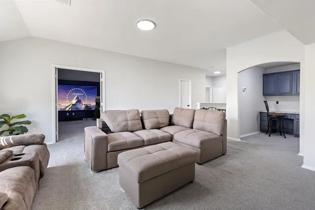 a living room with furniture a couch and a kitchen