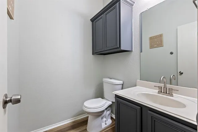 a bathroom with a granite countertop toilet sink and mirror